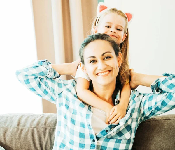 Любящая молодая мать смеется обнимаясь улыбаясь милая веселая дочь — стоковое фото