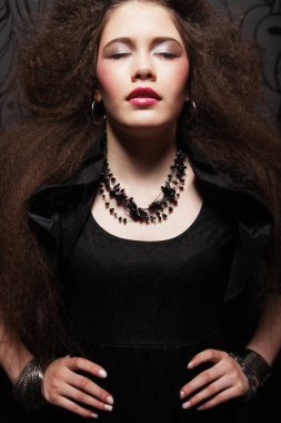 Kıvırcık saçlı ve parlak makyajlı güzel esmer kadın..