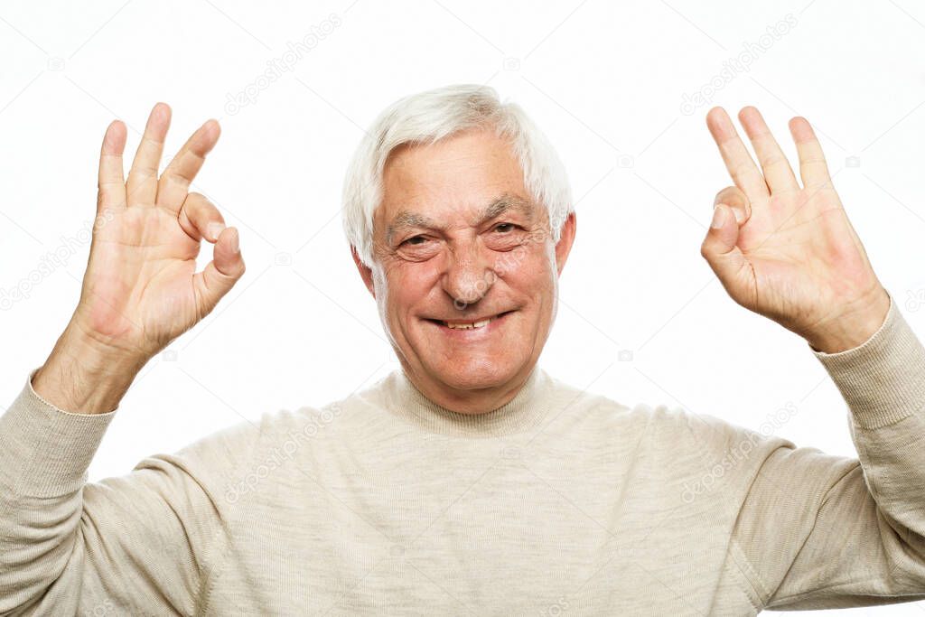 Emotion, lifestyle and old people concept: Portrait of energetic positive old man show okay sign