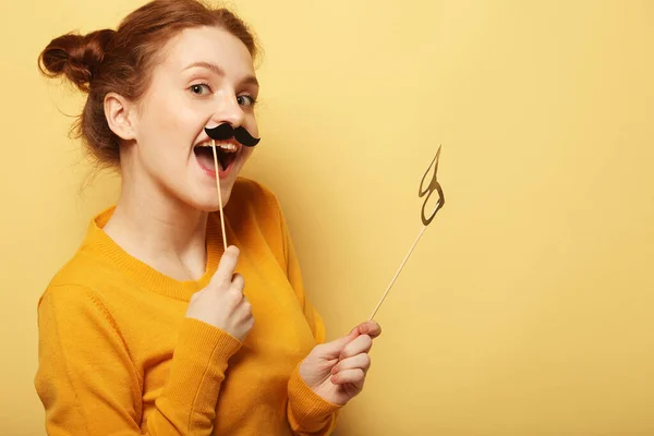 Lifestyle and people concept: Happy girl wearing fake mustaches — Stock Photo, Image