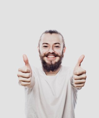 Beyaz arka planda izole edilmiş iyi bir hareket gösteren neşeli, sakallı genç bir adamın portresi.