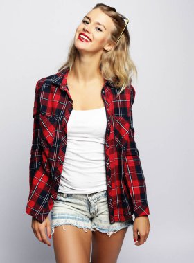 Kare gömlekli ve güneş gözlüklü çekici bir kadın.