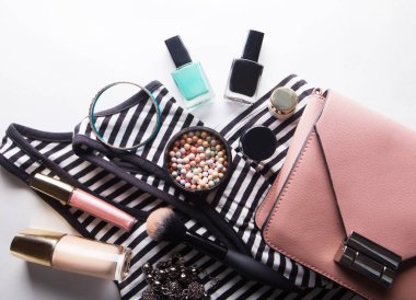 Gözlük, Vakfı, dudak parlatıcısı, toz, fırça, el çantası, çizgili gömlek üzerinde beyaz üstten görünüm izole ile stilize kadınsı flatlay.