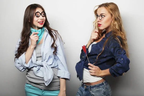 Two stylish female best friends holding paper party sticks, ready for party — Stock Photo, Image