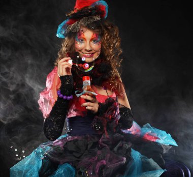 Yaratıcı makyajlı, sabun köpüğü üfleyen modaya uygun genç bir kadın. Bebek stili.