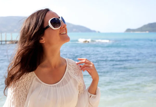 Glückliche Frau im weißen Sommerkleid am Strand. — Stockfoto