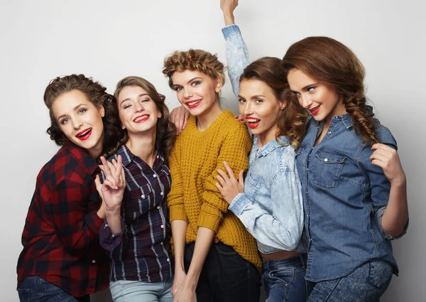 Beş kadın arkadaş gülüyor ve kameraya bakıyor.