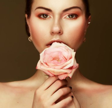 Zarif renklerde makyajlı güzel bir kadın büyük pembe bir çiçek tutuyor, güzellik konsepti, kapat.