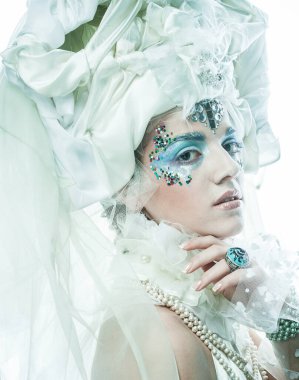 Parti, noel ve halk konsepti: mavi sanatsal makyajlı genç kadın. Kış Portresi. Kar Kraliçesi.