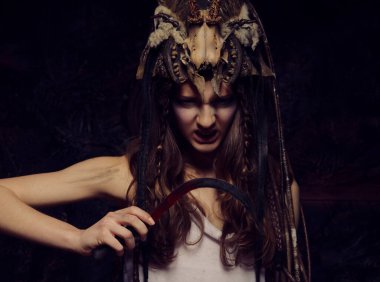 Elinde orak tutan saldırgan makyajlı genç bir kadın. Cadılar Bayramı. Kostüm partisi.