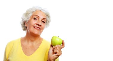 Elma tutan yaşlı güzel bir kadının portresi, gülümsüyor, beyaz arka planda soyutlanmış..