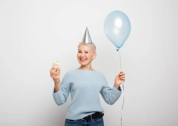 Happy Elderly Female Wearing Conical Hat Celebrating Birthday Cupcake Candle — Stock Photo, Image