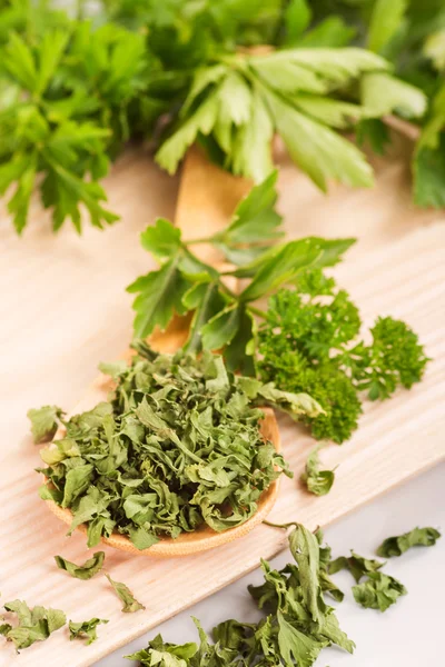 Dried herbs parsley and celery on a wooden spoon. Royalty Free Stock Photos