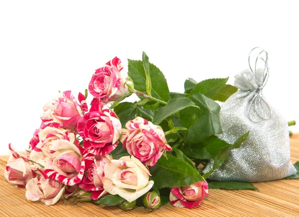 Bouquet van rozen en een geschenk aan de ondergrond. — Stockfoto