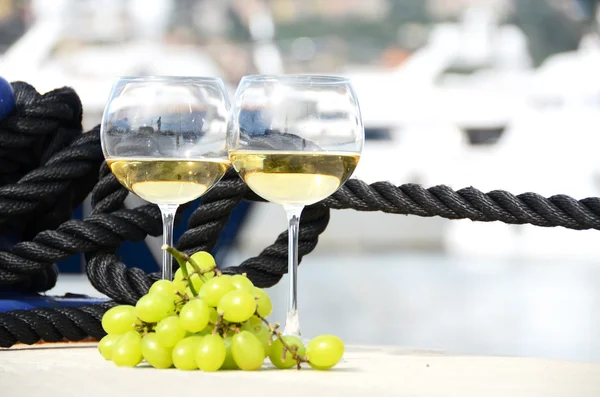 Pair of wineglasses and grapes against the yacht pier of La Spez — Stock Photo, Image