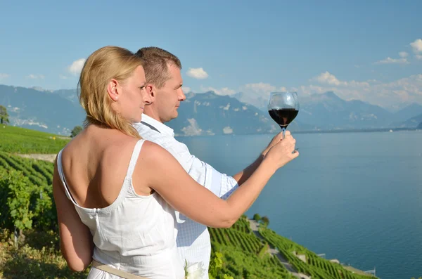 Man and woman tasting wine among vineyards in Lavaux, Switzerlan — Stock Photo, Image