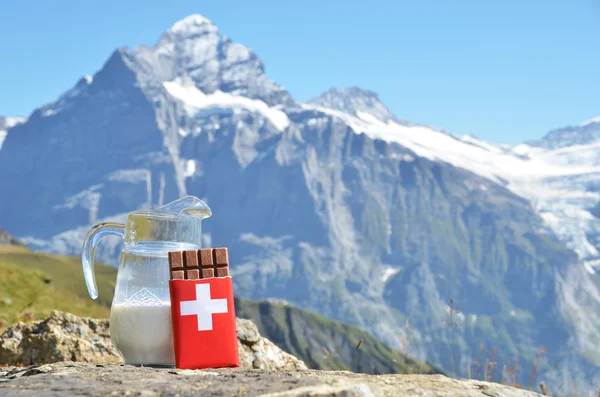 Schweizisk choklad och kanna mjölk mot bergstoppen. switzerla — Stockfoto