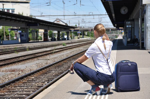 Menina na estação ferroviária à espera de um trem — Fotografia de Stock