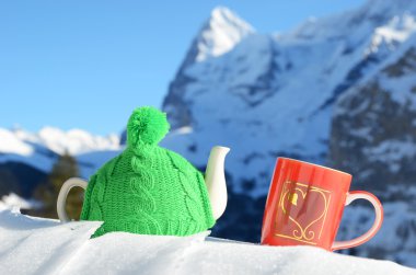 kar bir kalp ile örme kap ve kırmızı fincan çay potu