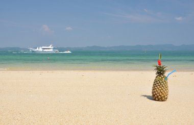 Pineapple cocktail on a tropical beach clipart
