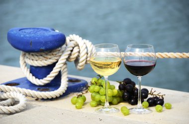 Pair of wineglasses and grapes on the pier clipart