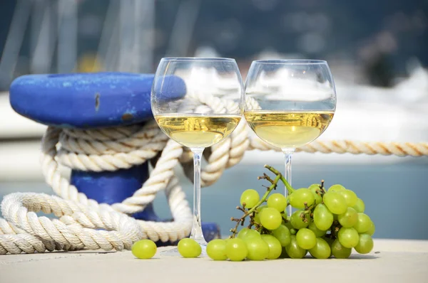 Pair of wineglasses and grapes against the yacht pier of La Spez — Stock Photo, Image