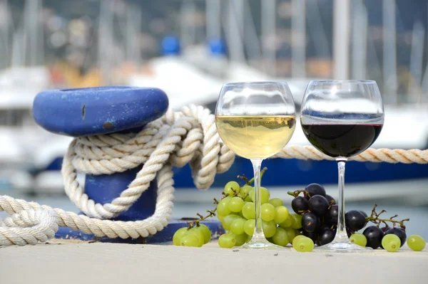 Pair of wineglasses and grapes against the yacht pier of La Spez — Stock Photo, Image