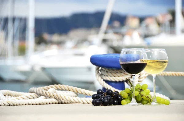 Pair of wineglasses and grapes against the yacht pier of La Spez — Stock Photo, Image