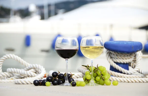 Pair of wineglasses and grapes against the yacht pier of La Spez — Stock Photo, Image