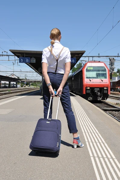 Dívka s kufrem na vlakovém nádraží — Stock fotografie
