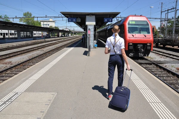 Lány egy bőröndöt a vasútállomáson — Stock Fotó