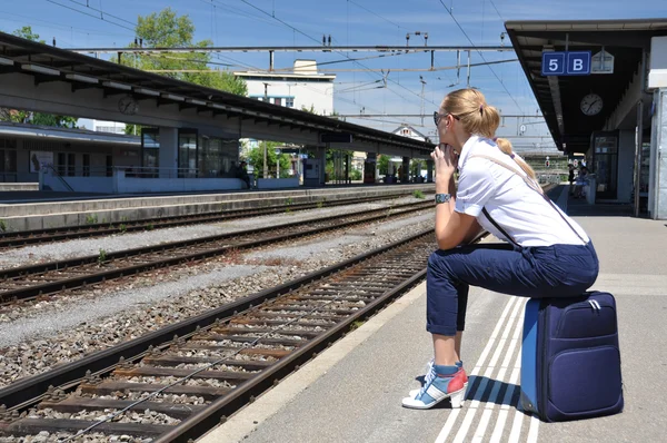 Dívka s kufrem na vlakovém nádraží — Stock fotografie