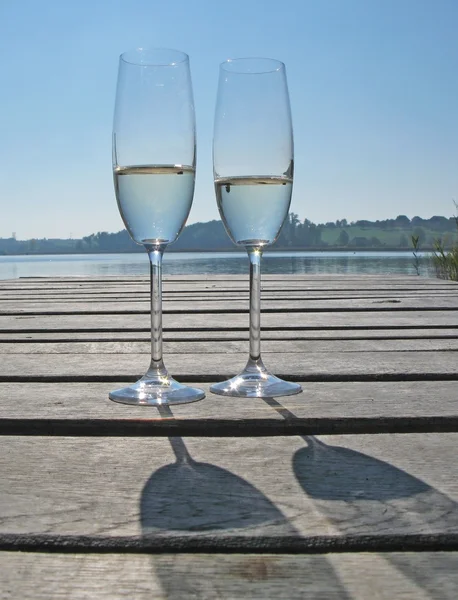 Deux verres de champagne contre un lac — Photo