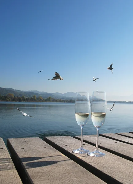 Zwei Sektgläser gegen einen See — Stockfoto