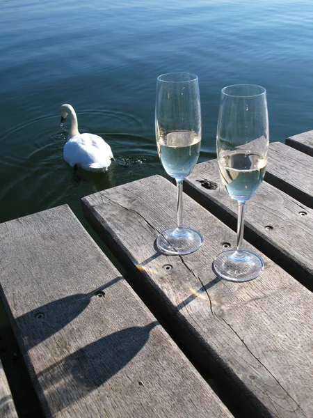 Due bicchieri di champagne contro un lago — Foto Stock