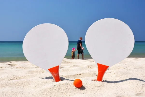 两个球拍和球在沙滩上 — 图库照片