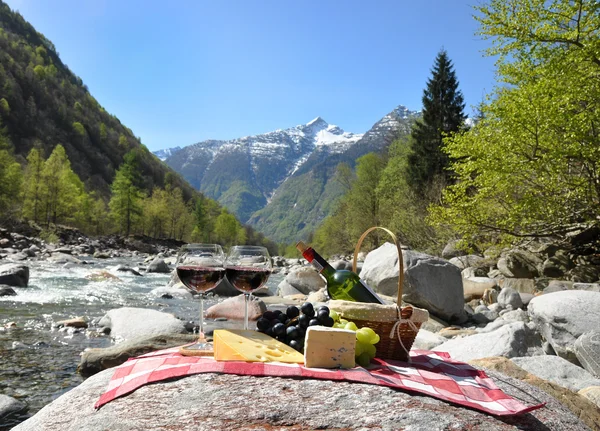 Vino tinto, queso y uvas servidas en un picnic. Valle de Verzasca , — Foto de Stock