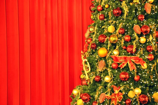 Christmas tree against red drapery — Stock Photo, Image