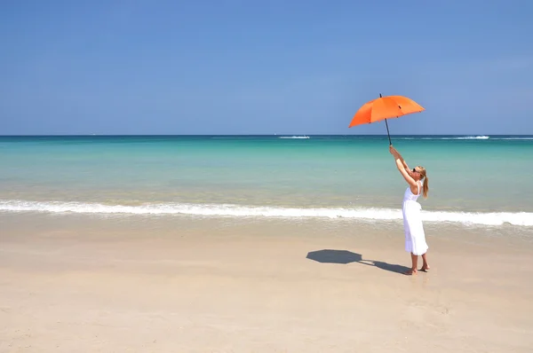 Ragazza con un ombrellone arancione sulla spiaggia di sabbia — Foto Stock