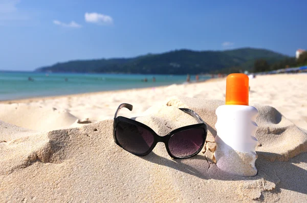 Sonnenbrille und Lotion am Sandstrand der Insel Phuket, Thailand — Stockfoto