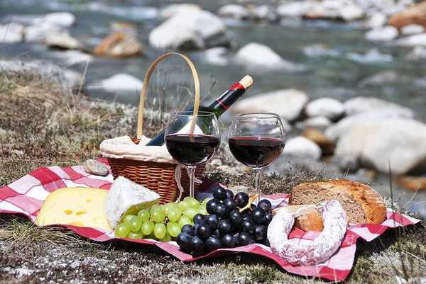 Red wine, cheese and grapes served at a picnic. Verzasca valley, — Stock Photo, Image