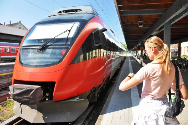 Flickan tittar på sin klocka på stationen — Stockfoto