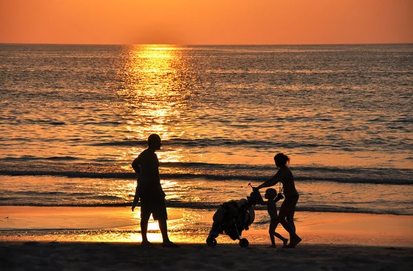 Rodzina na plaży o zachodzie słońca Obrazek Stockowy