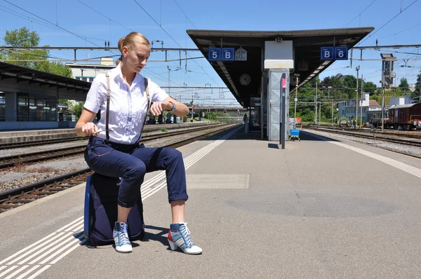 Fille à la gare regardant sa montre — Photo