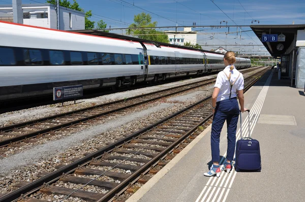 Lány egy bőröndöt a vasútállomáson — Stock Fotó