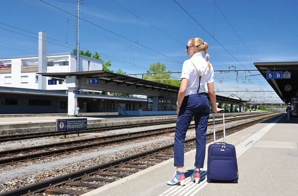 Lány egy bőröndöt a vasútállomáson — Stock Fotó