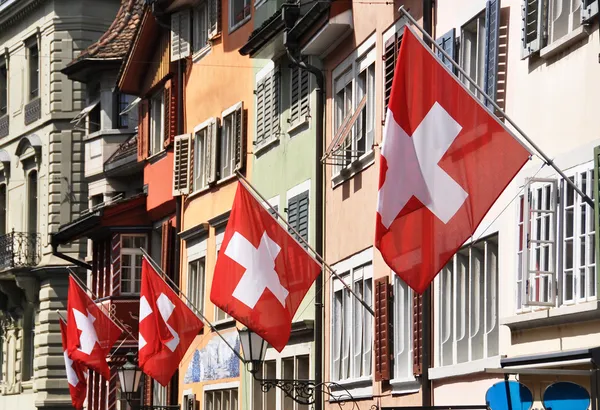 Old street in Zurich decorated with flags for the Swiss National — Stock Photo, Image