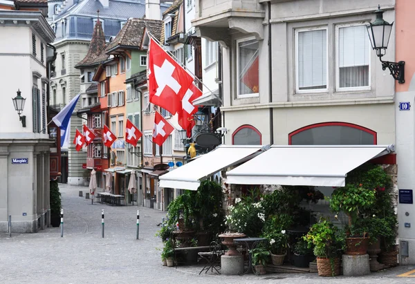 Stary ulica w Zurychu ozdobione flagi dla swiss national — Zdjęcie stockowe