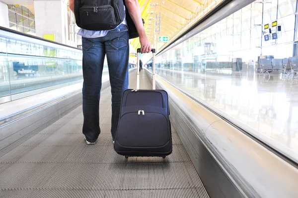 Traveler with a suitcase on the speedwalk — Stock Photo, Image