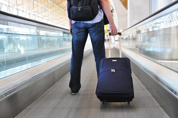 Traveller with a suitcase on the speedwalk — Stock Photo, Image